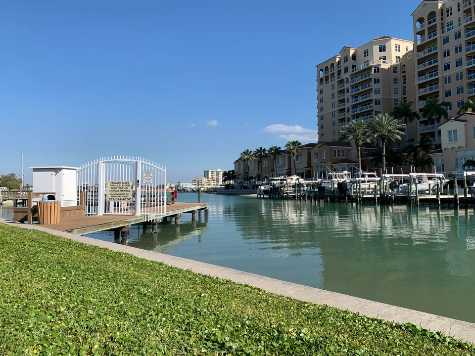 Boats, private slips and waterfront buildings along a Clearwater harbor-side walkway