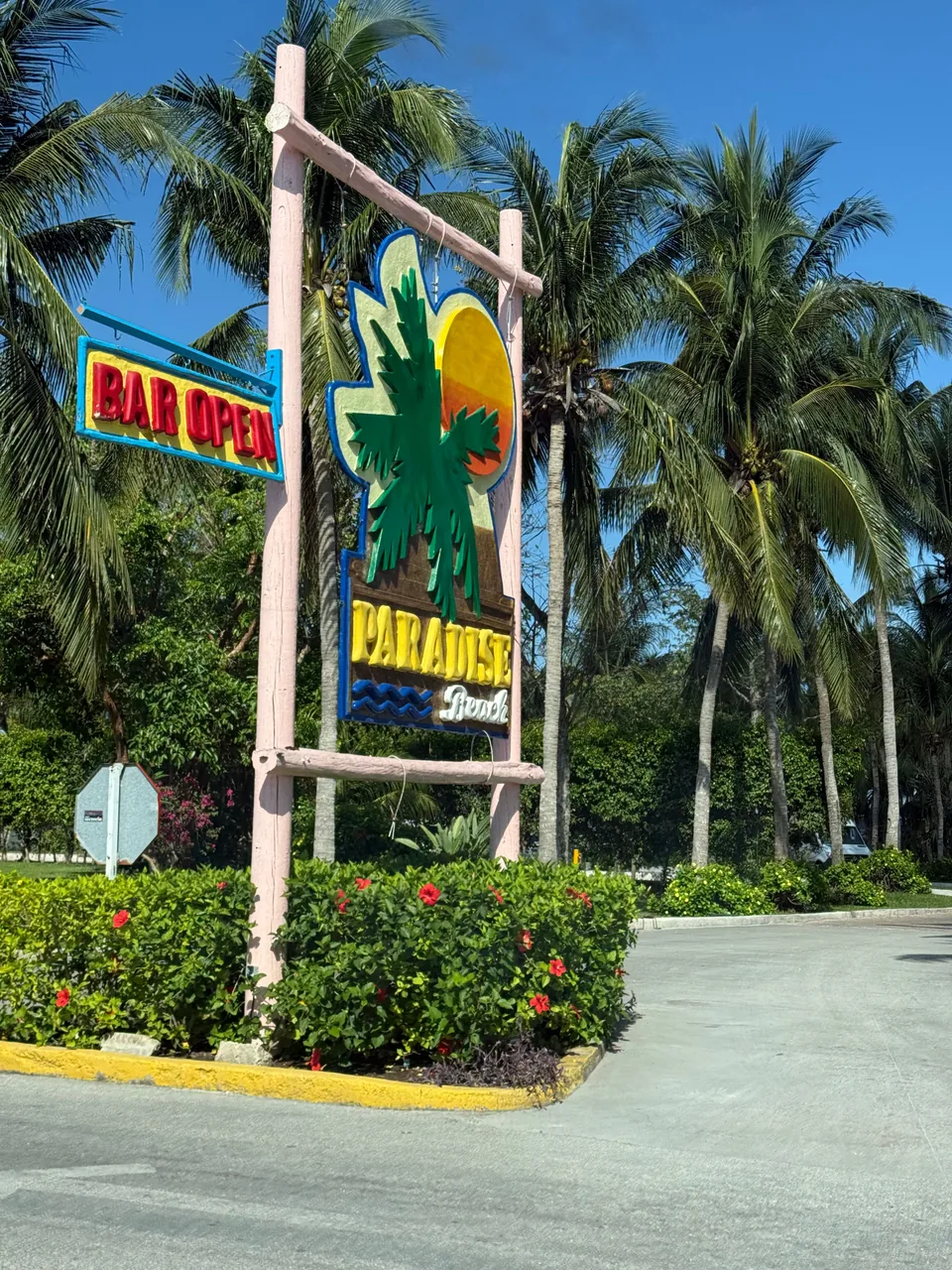 Paradise Beach entrance sign surrounded by palm trees in Cozumel