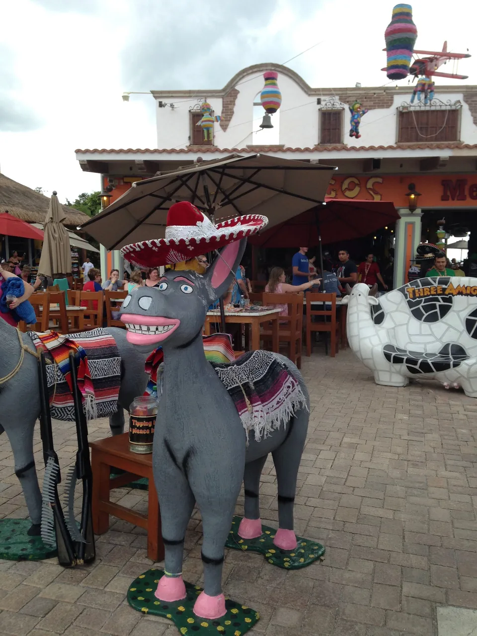 Colorful donkey figures beside a Cozumel port-area restaurant and shopping courtyard
