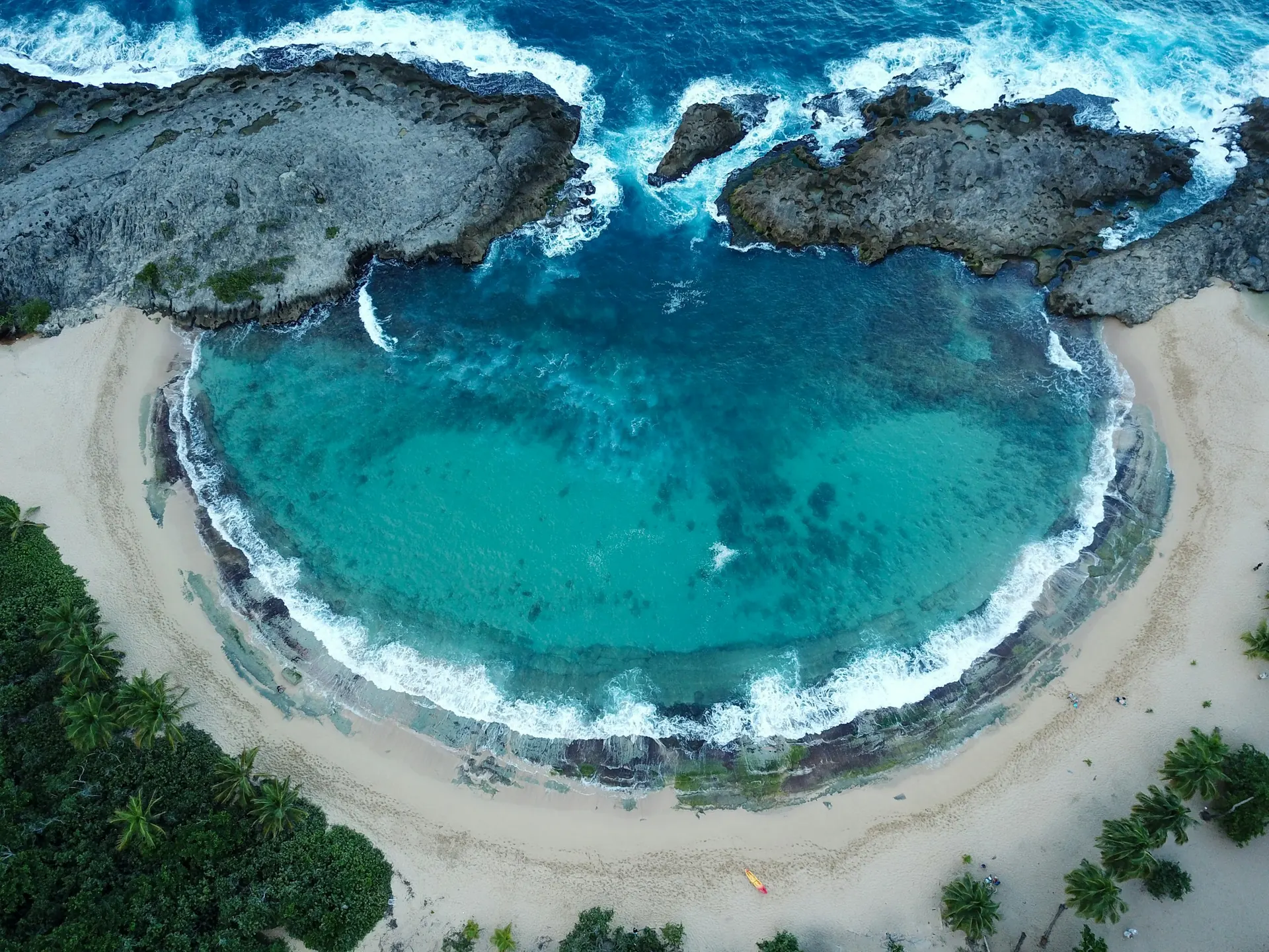 Aerial view of the limestone-framed turquoise cove at Mar Chiquita