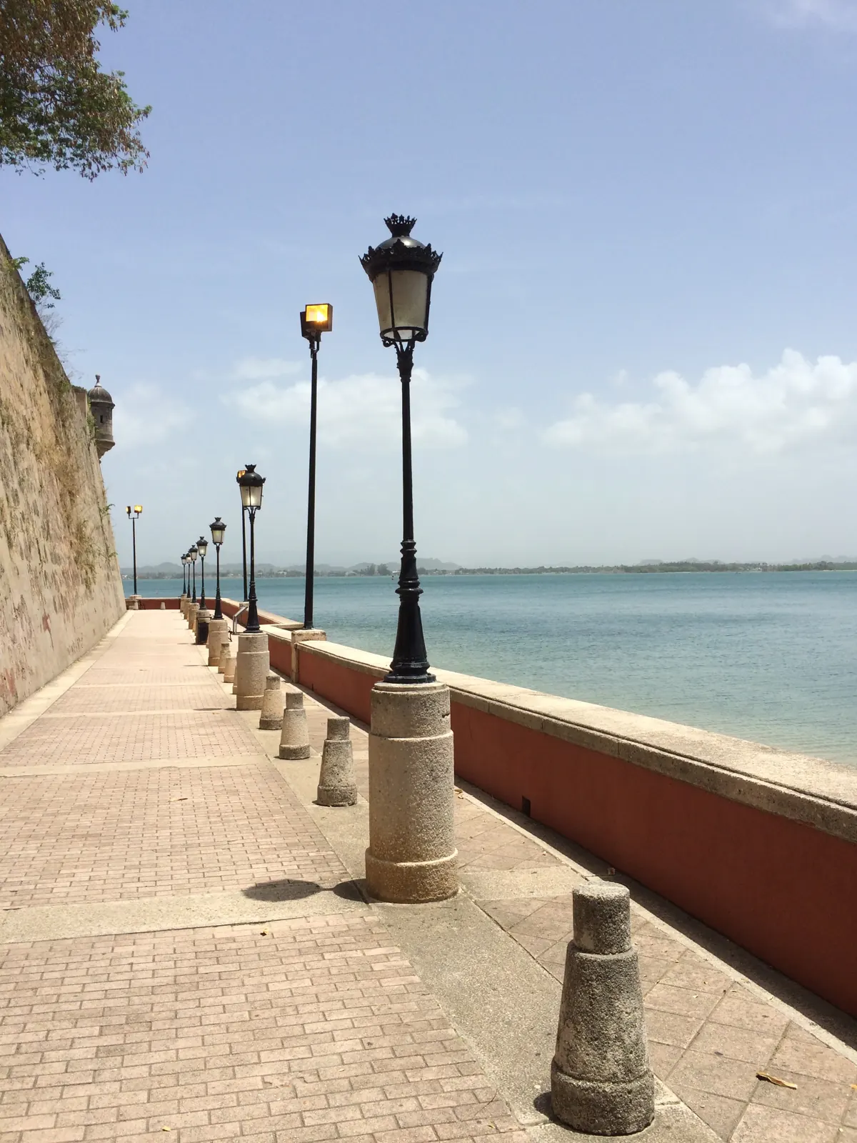 Waterfront pedestrian walkway and lamps beside the walls of Old San Juan