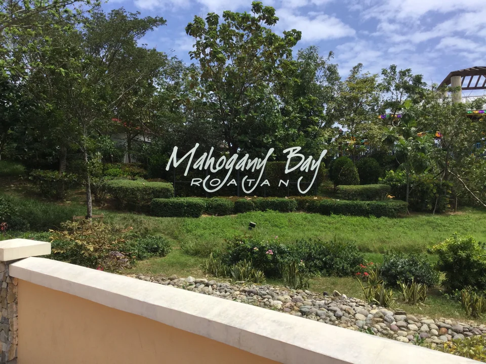 Mahogany Bay Roatán sign surrounded by tropical landscaping